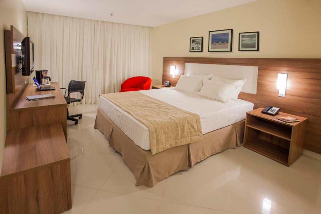 a hotel room with a large bed and a desk at Holiday Inn Express Belem Ananindeua by IHG in Belém
