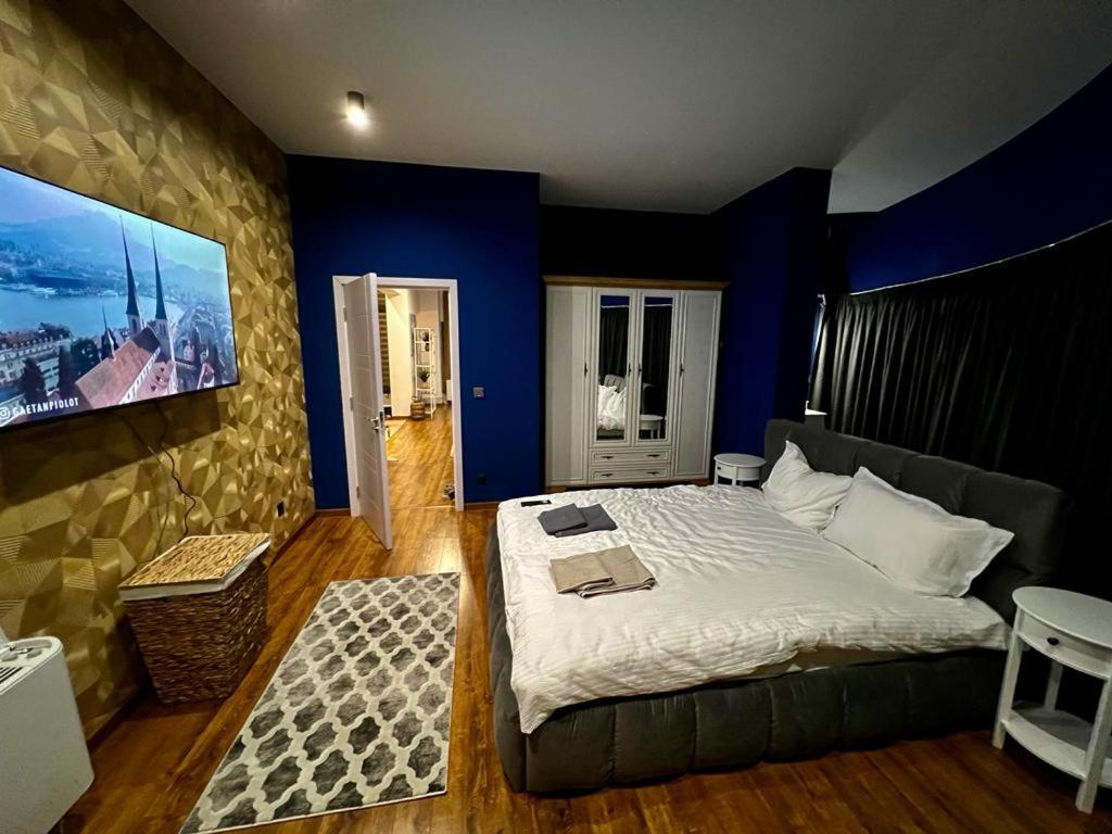 1 dormitorio con 1 cama grande y paredes azules en ROOF TOP LUXURY en Blagoevgrad