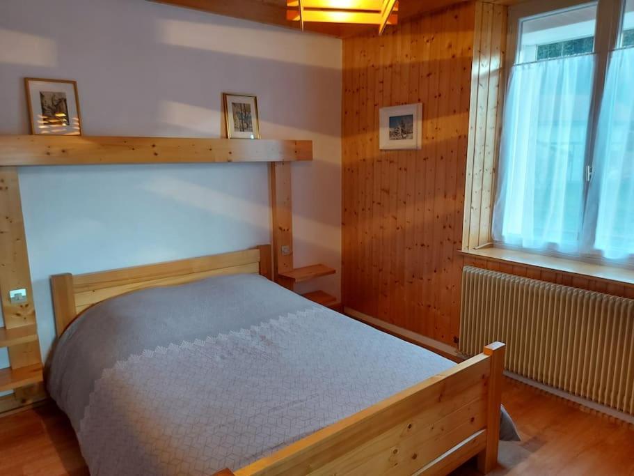 a bedroom with a bed and a window at Bel appartement dans une ferme Vosgienne in Xonrupt-Longemer