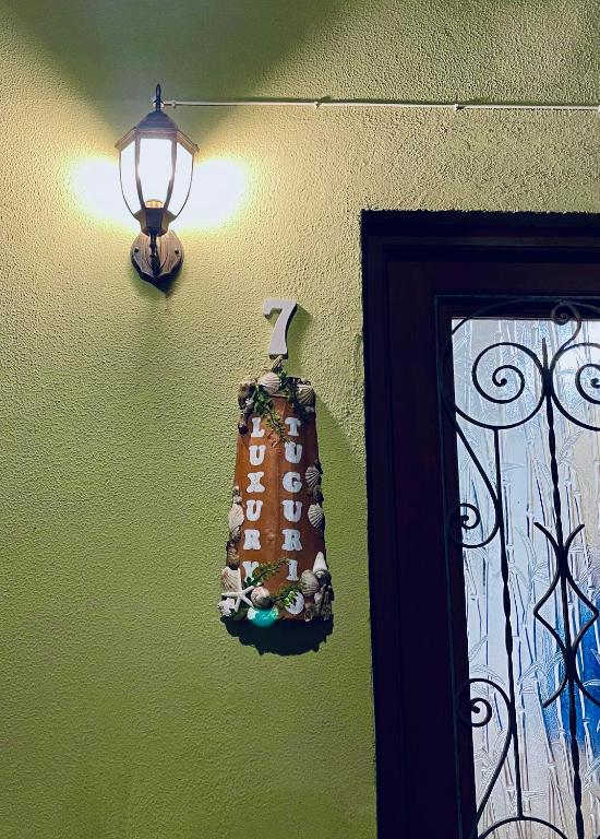 a light on a green wall with a bag on it at Luxury Tugurio in Arma di Taggia