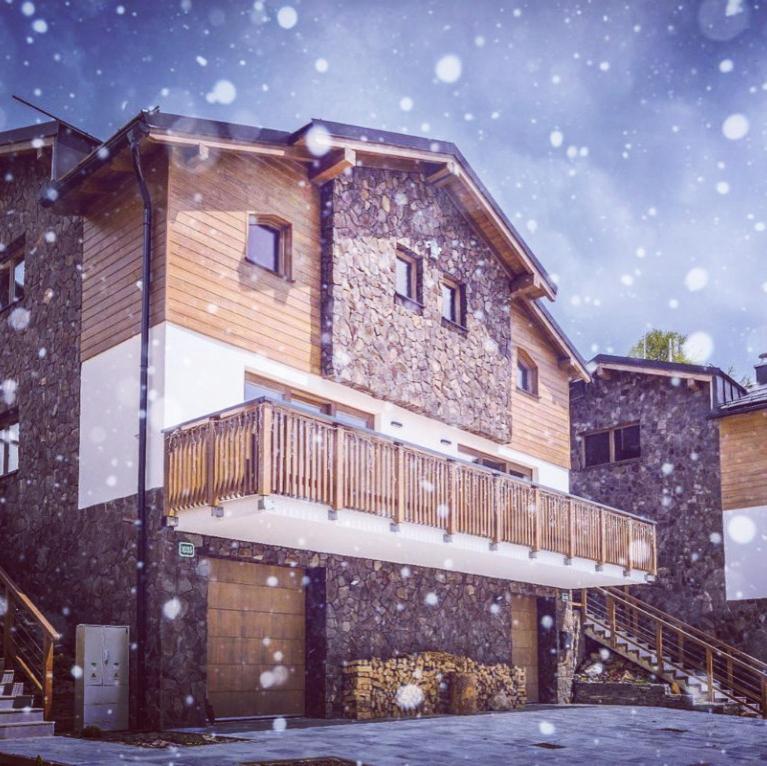 een huis met een terras in de sneeuw bij Horská Chata Ostružiny in Donovaly
