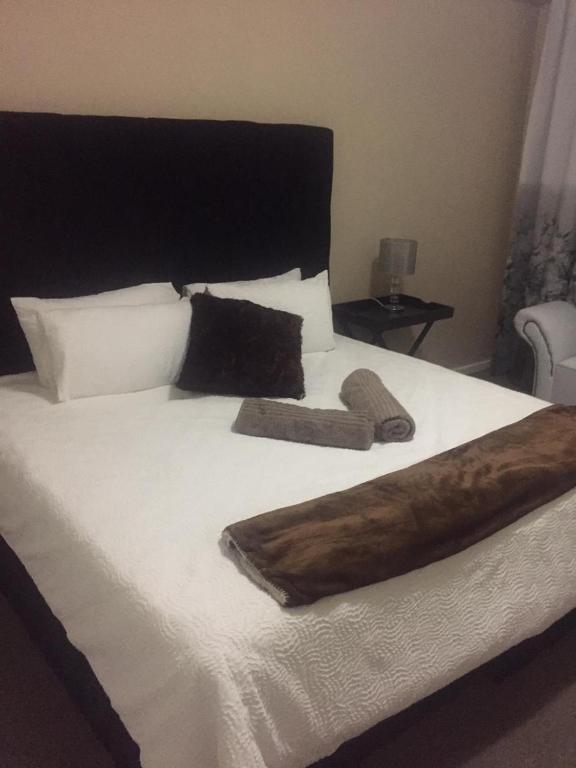 a large bed with white sheets and pillows at Kennaway Court in East London