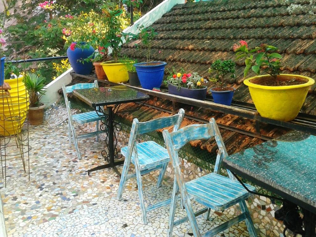 a group of chairs and tables with potted plants at Afonso Guest House - Fontainhas in Panaji