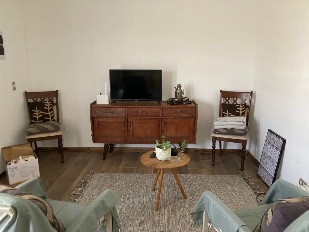 a living room with a tv and two chairs at Container home in Santa Teresa de Lo Ovalle