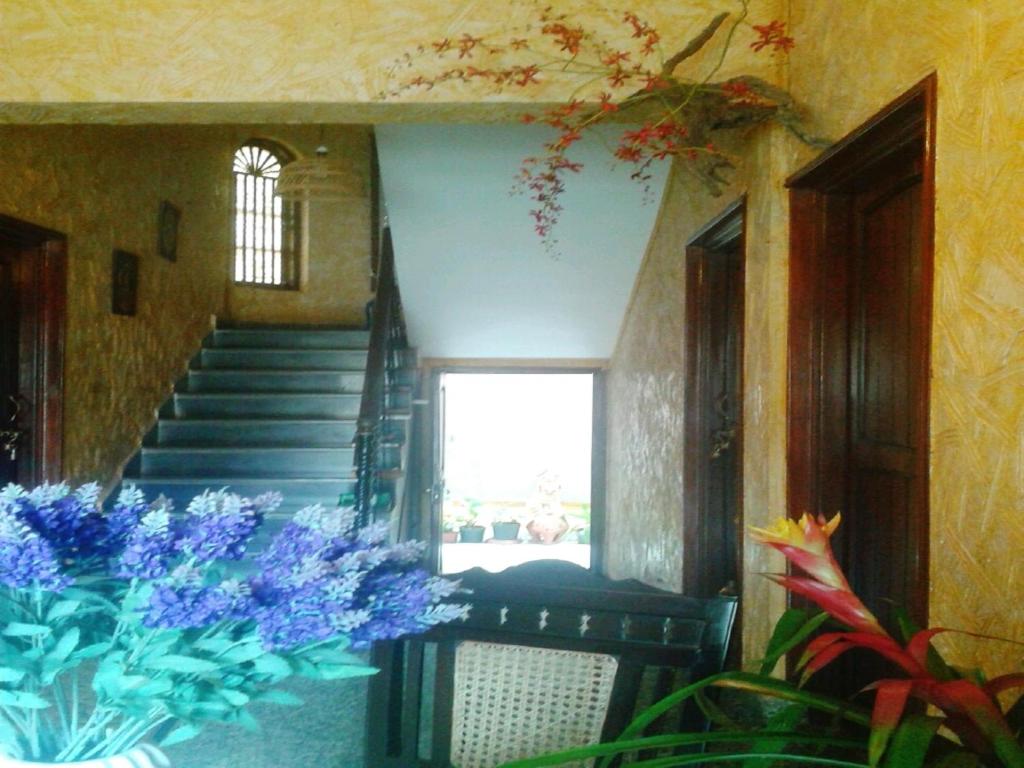 a hallway with stairs and blue flowers in a room at Afonso Guest House - Fontainhas in Panaji