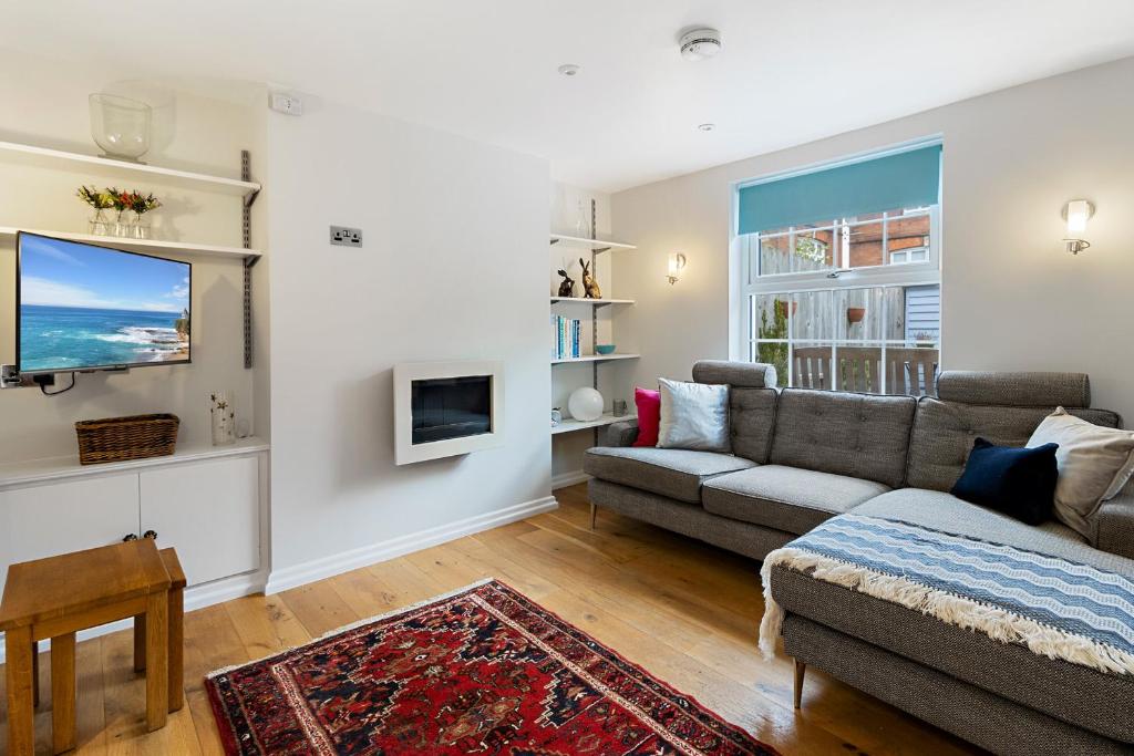 a living room with a couch and a tv at Dillywicks by Staytor Accommodation in Exeter