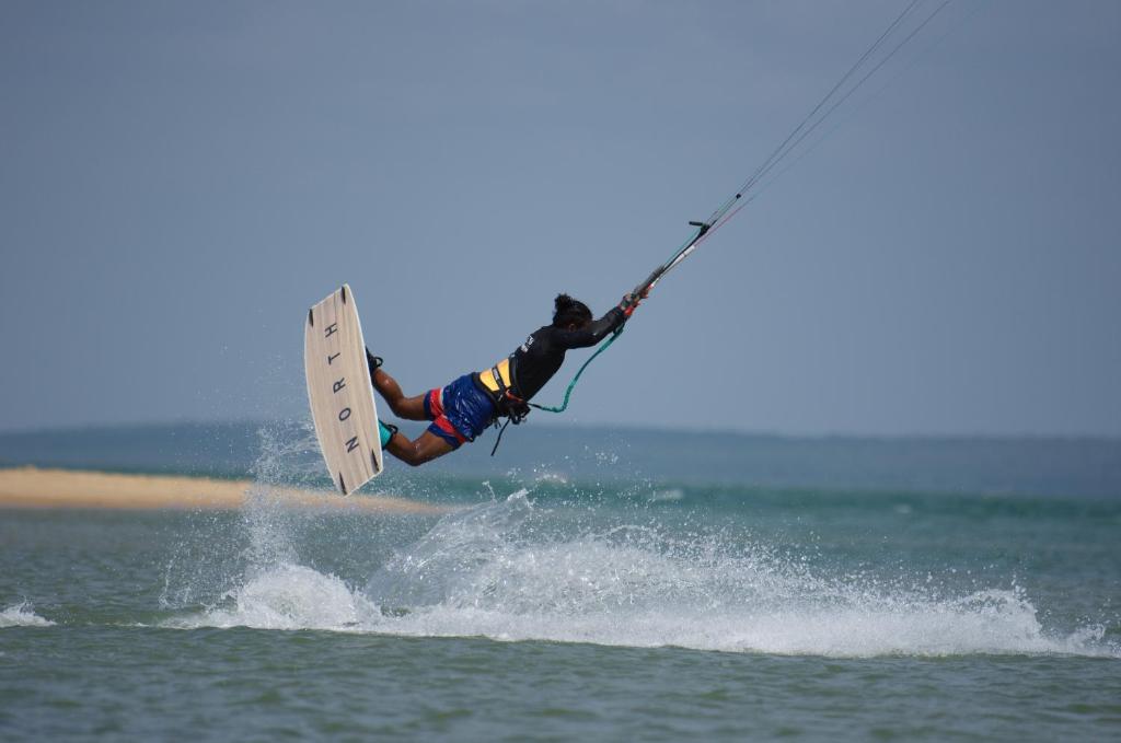 a person on a surfboard in the water at De Silva Wind Resort Kalpitiya - Kitesurfing School Sri Lanka in Kalpitiya