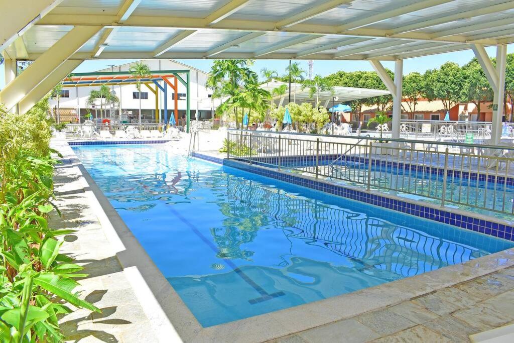 uma piscina num resort com água azul em dirioma fiori 410 descanso, paz, alegria e muita diversão em águas termais em Caldas Novas