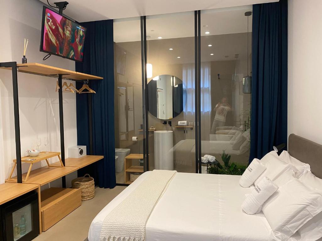 1 dormitorio con 1 cama grande y baño en Nu House Rooms & Apartments, en Cassano delle Murge