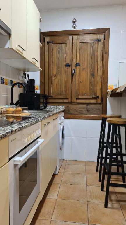 a kitchen with wooden cabinets and a stove top oven at El Rinconcito de la Merced in Toledo