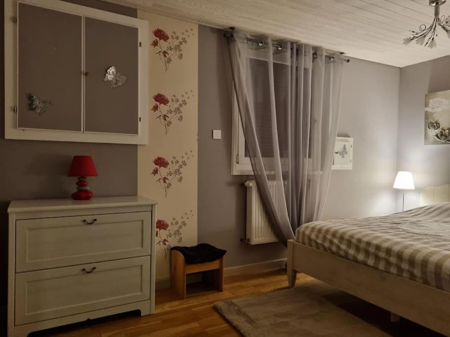 a bedroom with a bed and a dresser and a window at Appartement chaleureux et confortable avec sauna.. in Le Chenit