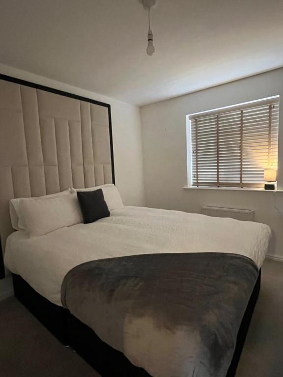 a bedroom with a large white bed with a window at Hawk House - Furnished Accommodation in Hatfield