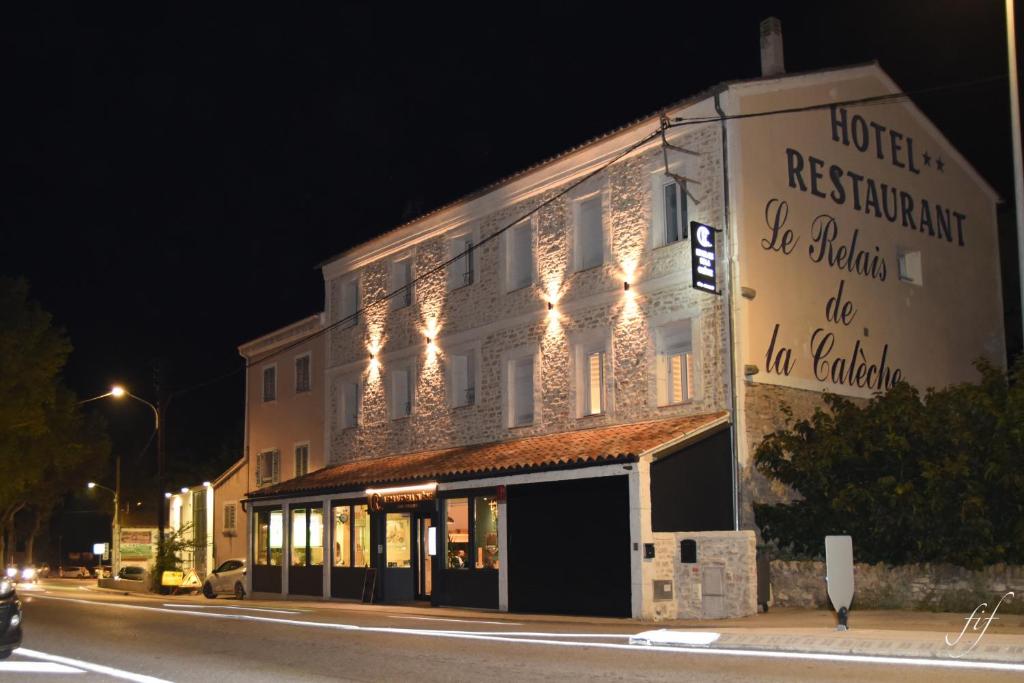 un edificio al lado de una calle por la noche en Le Relais de la Calèche en Le Beausset