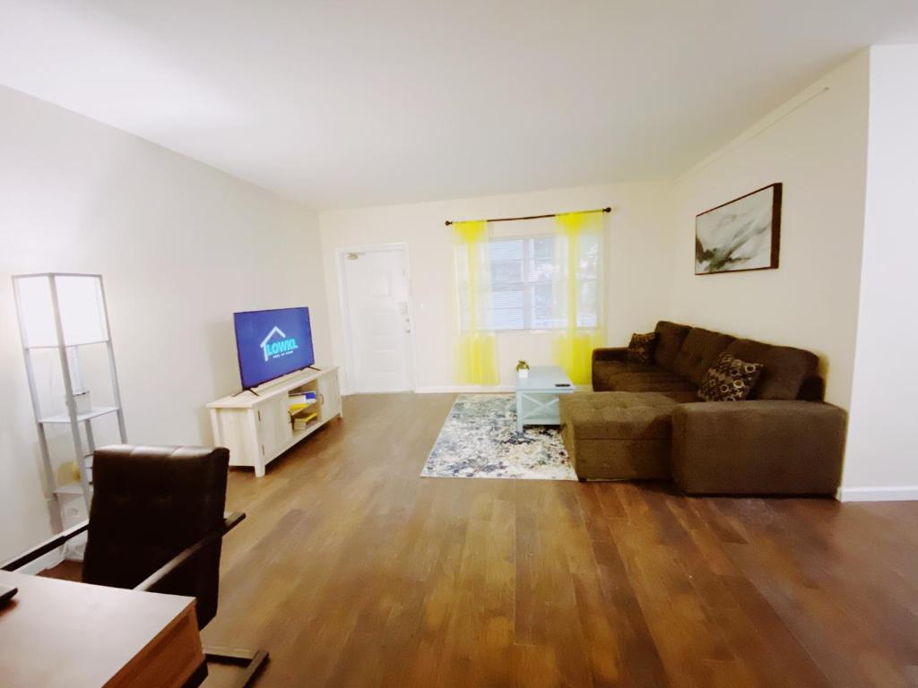 a living room with a couch and a tv at Bayview Regency Apartments By Lowkl in Fort Lauderdale