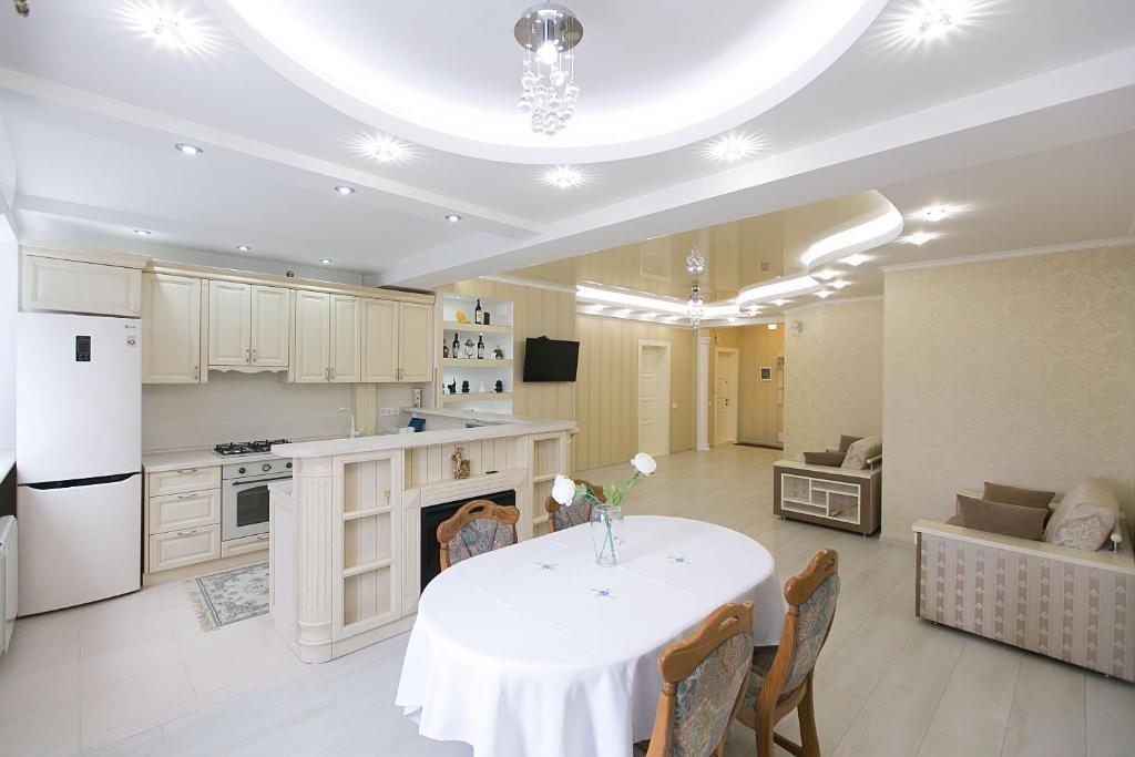 a kitchen with a table with a vase of flowers on it at White Sky Apartment in Chişinău