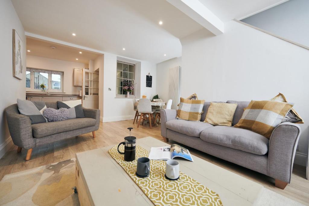 a living room with two couches and a table at Towy Snug in Llandeilo