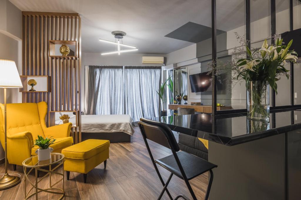 a living room with a yellow chair and a bedroom at K-Houses A4 in Arta