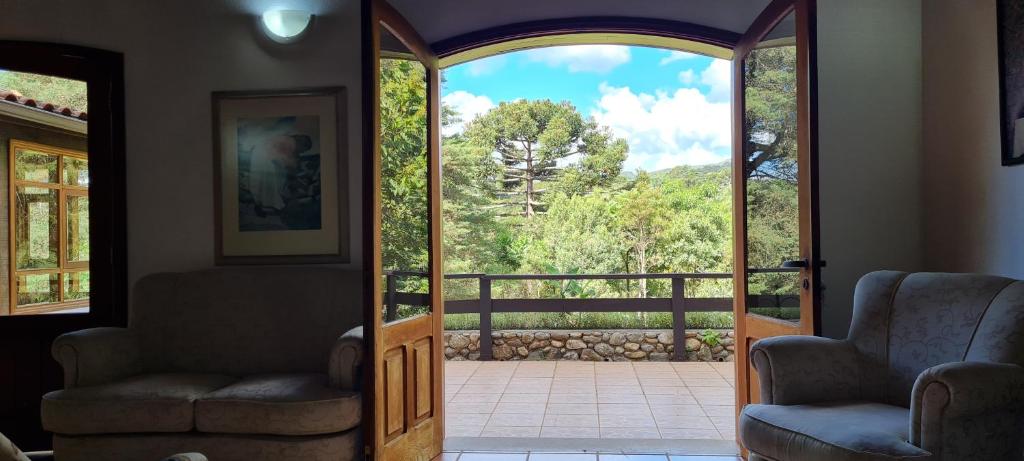 a living room with a door open to a patio at Arado 313 Suites in Monte Verde