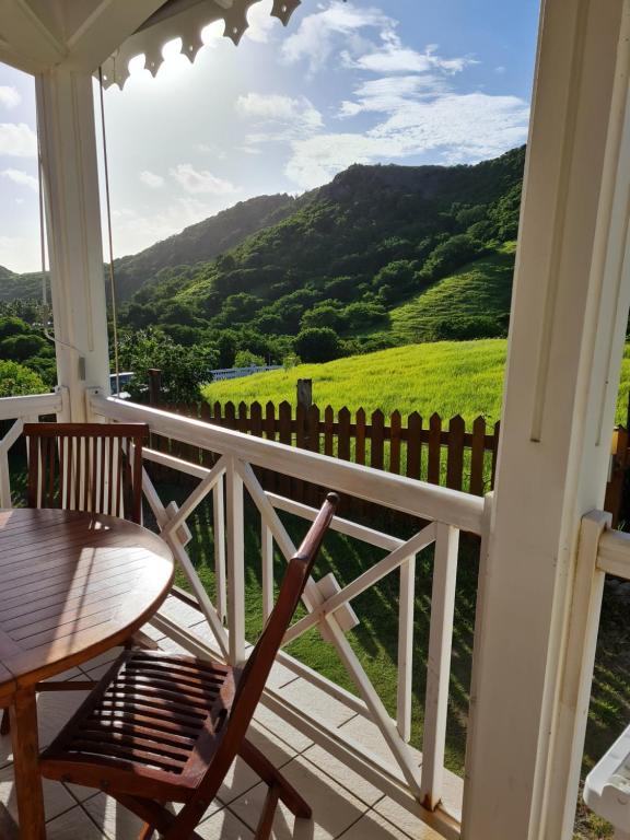 - une vue depuis la terrasse couverte d'une maison avec une table et des chaises dans l'établissement Chez Gisèle et Philippe, à Terre-de-Haut