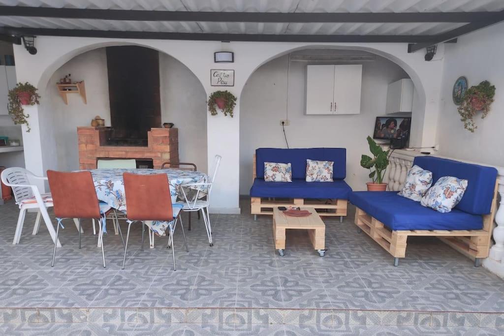 CAL TIO PAU في Orba: غرفة معيشة مع طاولة وأريكة زرقاء