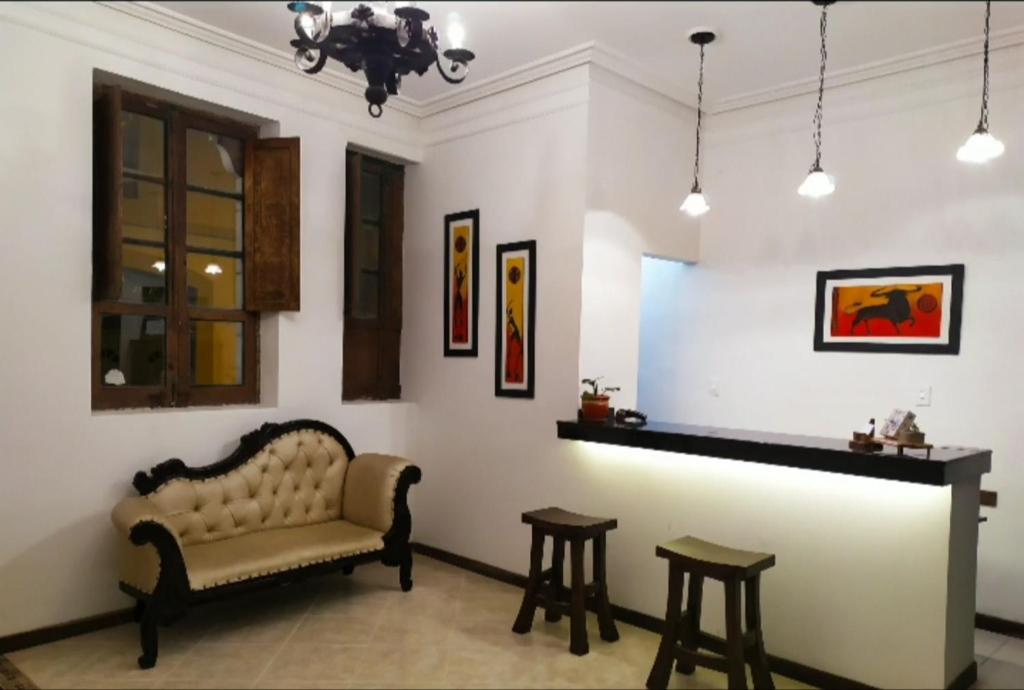 a living room with a couch and two stools at Hotel La Gran Casona in Tunja