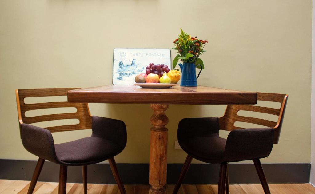a table with a bowl of fruit and a vase of flowers at Old Town Quito Suites, Heritage Boutique Hotel, Where Every Detail Tells a Story in Quito