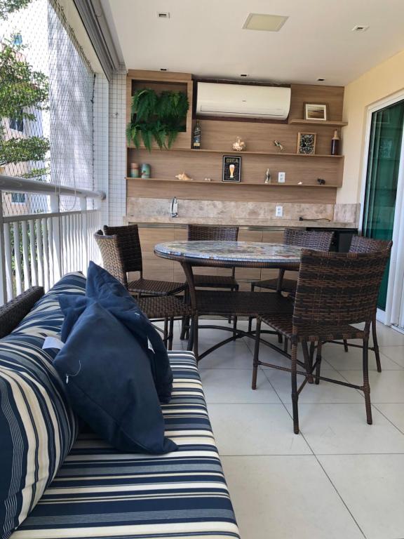 a dining room with a table and chairs on a balcony at Apto de luxo no Golfville Ideal para família e home office Prox do Beach Park in Aquiraz