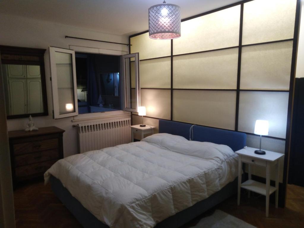 - une chambre avec un grand lit et 2 tables de chevet dans l'établissement appartamento centro storico, à Monfalcone