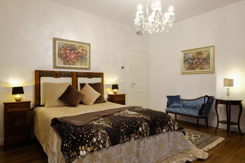 een slaapkamer met een bed en een kroonluchter bij B&B Old Town San Marino in San Marino