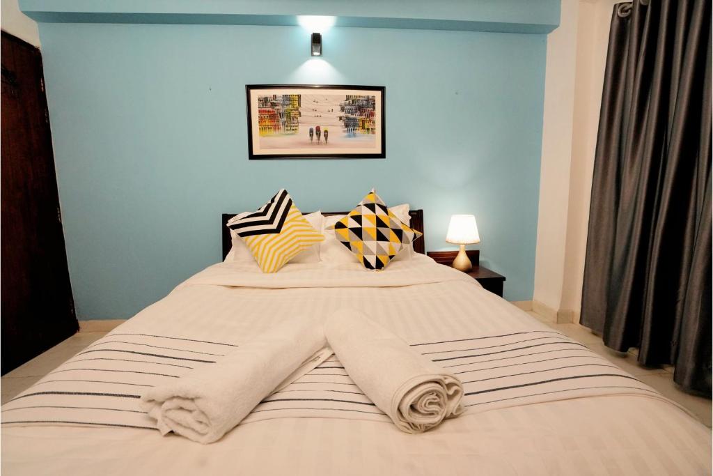 sypialnia z dużym łóżkiem z niebieskimi ścianami w obiekcie Gulshan Lovely 3-Bedroom Luxury Apartment w mieście Dhaka