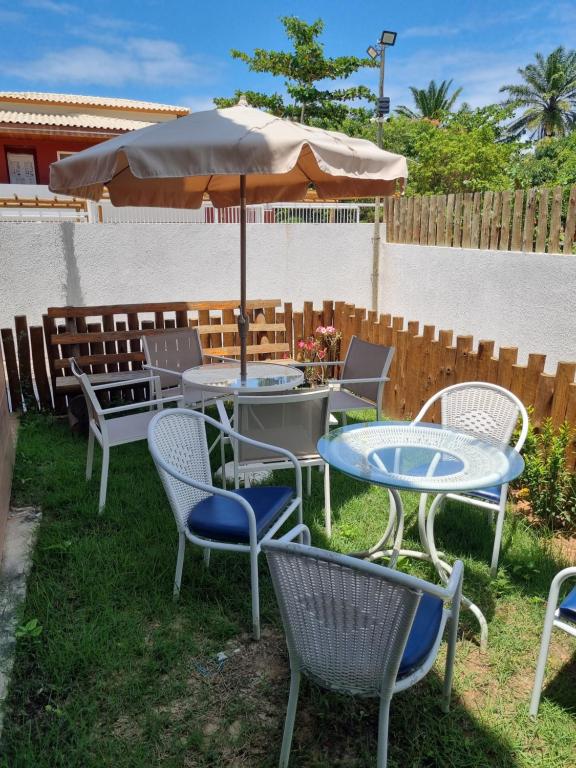 a group of tables and chairs with an umbrella at Riverside imbassai bloco B003 in Mata de Sao Joao