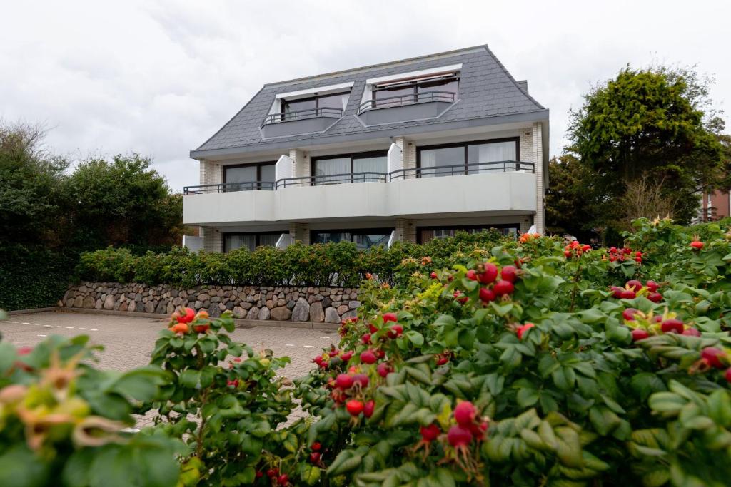 uma casa com um ramo de flores à frente dela em Haus Oose em Westerland