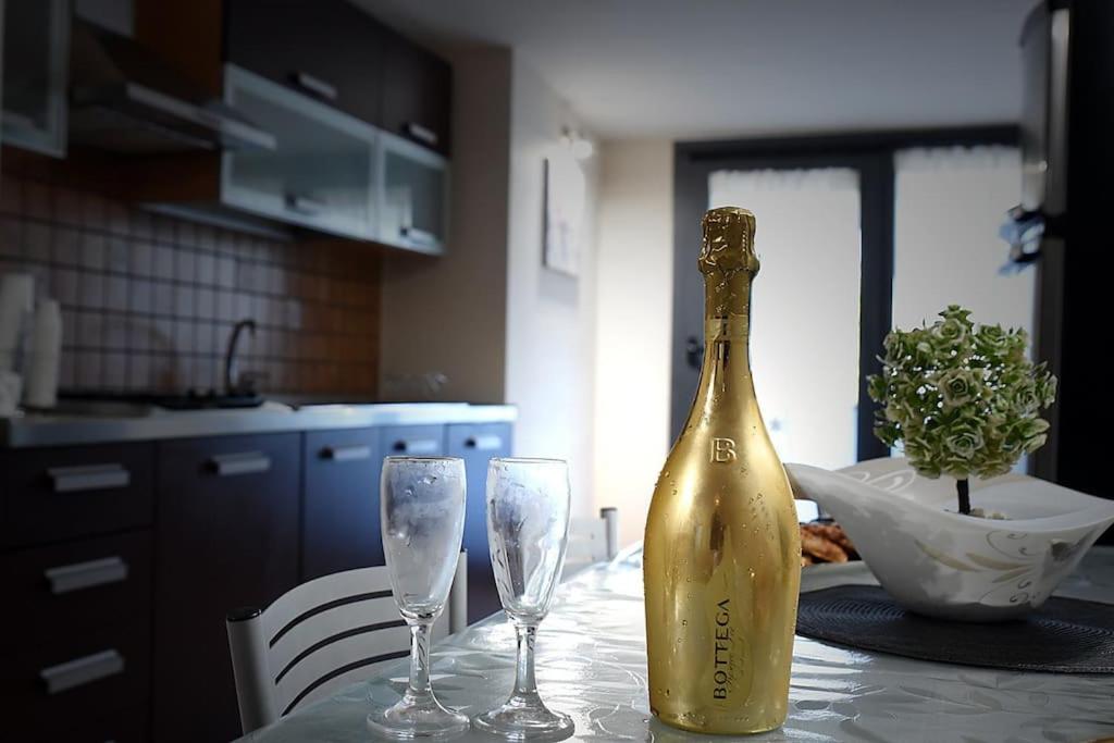Una botella de champán sentada en una mesa con dos copas. en Valentino Bed And Breakfast, en Capodrise