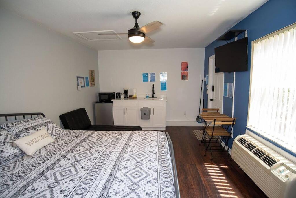 a bedroom with a large bed and a kitchen at Cozy Studio Apartment close to Disney in Davenport