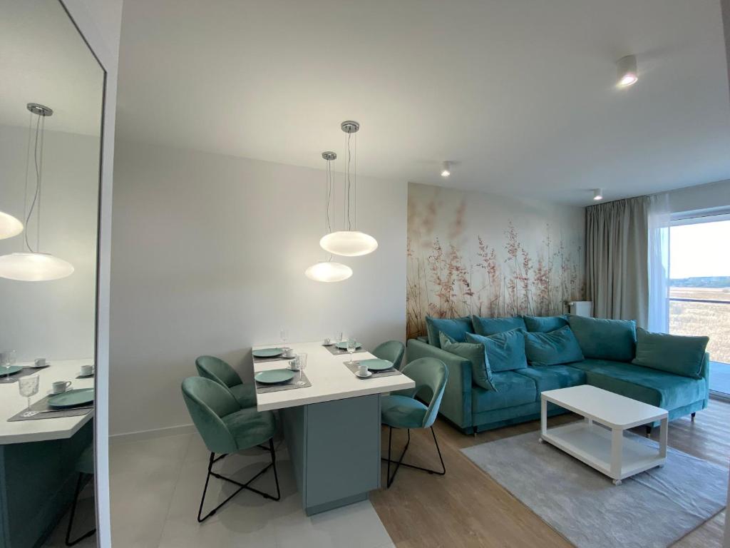 un soggiorno con divano blu e tavolo di MIZU Apartamenty - Westin a Kołobrzeg