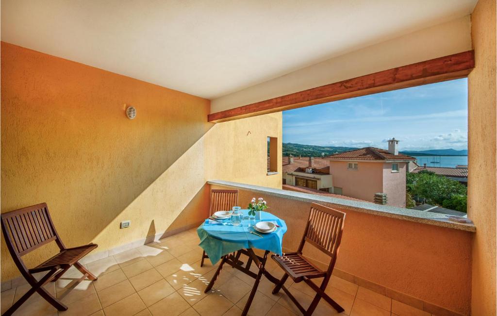 a balcony with a table and chairs and a large window at 1 Bedroom Beautiful Apartment In Isola Rossa in Isola Rossa