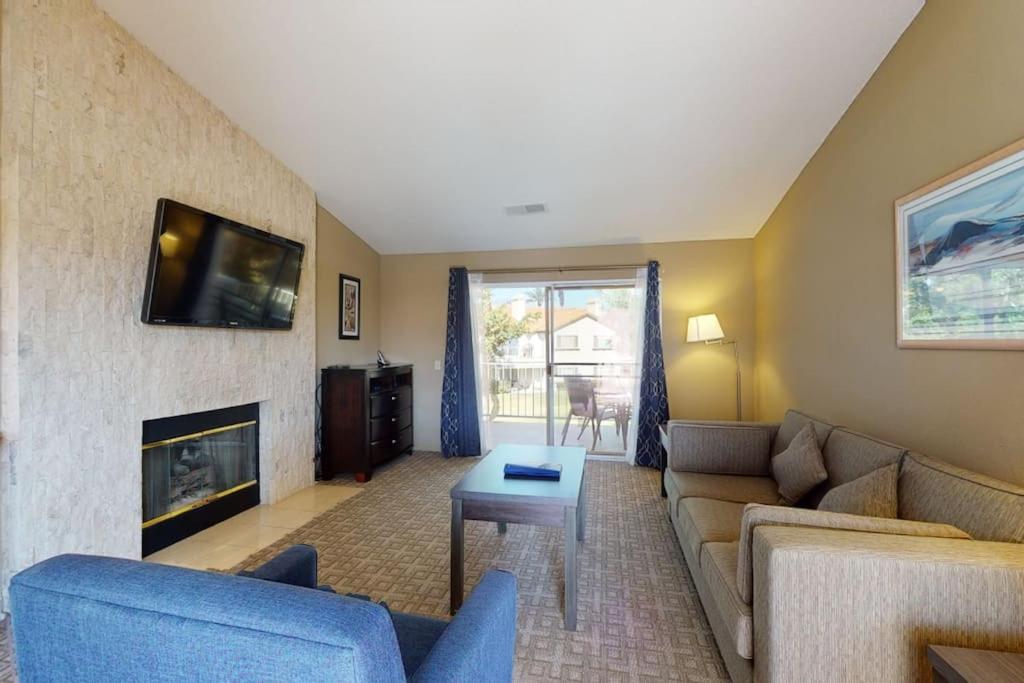 a living room with a couch and a fireplace at DF202 Airy 2 Bedroom Condo Overlooking the Pool in Palm Desert