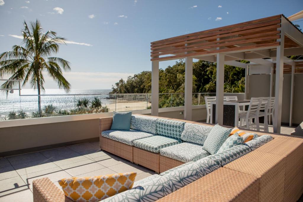 a couch on a patio with a view of the ocean at Netanya Noosa - Beachfront Resort in Noosa Heads