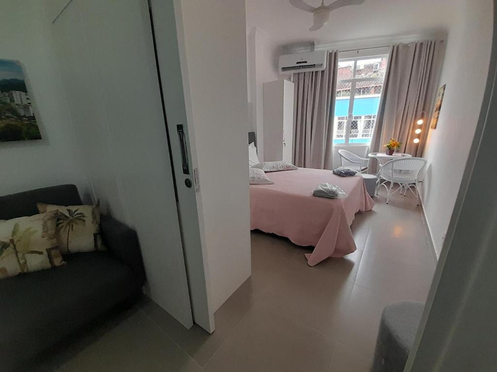 a bedroom with a bed and a table and a window at Quadra Praia, Posto 4, Split, smarttv Cabo, wifi , 35m2 in Rio de Janeiro