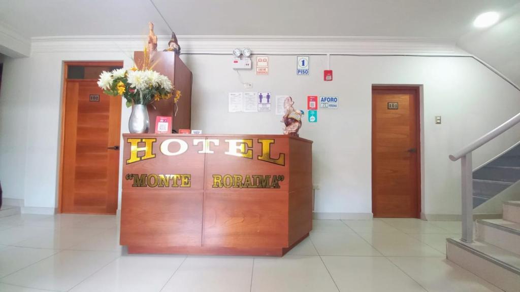 a hotel entrance with a hotel welcome sign and flowers at Hotel Monte Roraima in Huancayo