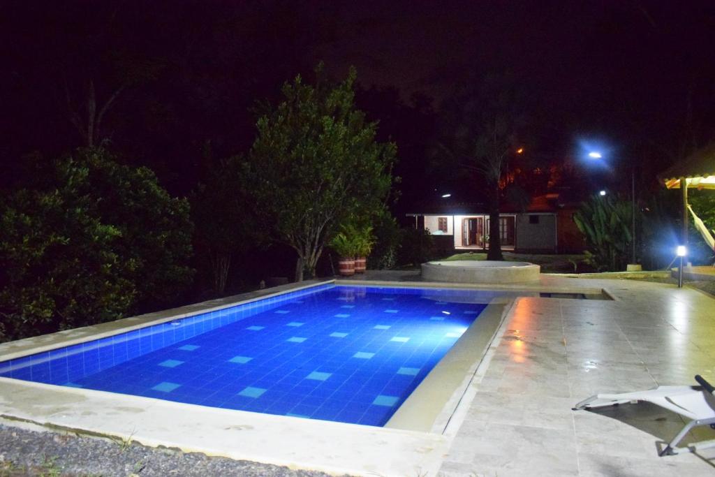 a swimming pool in a yard at night at Finca Milandia in Villeta