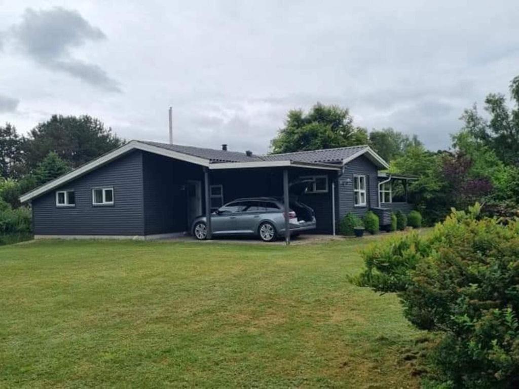 a house with a car parked in front of it at 7 person holiday home in Højslev-By Traum in Højslev