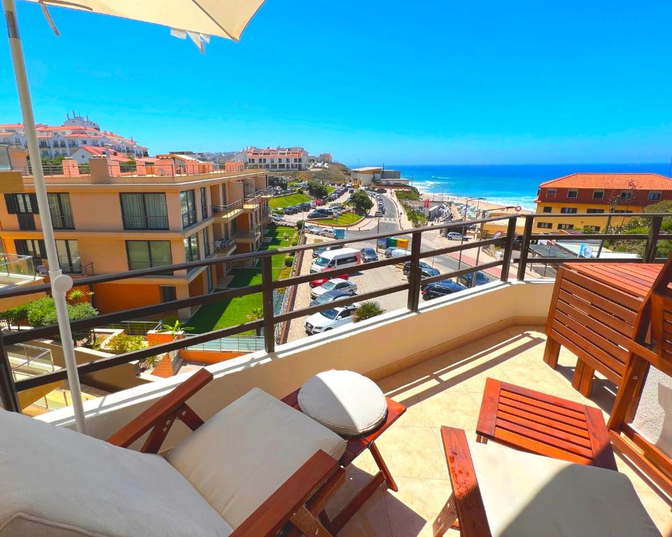balcón con vistas a la playa y al océano en Apartamento Frente Mar Praia da Areia Branca, en Praia da Areia Branca