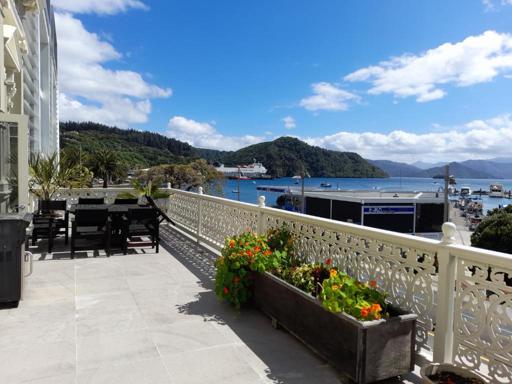 a balcony with a table and flowers on a building at Oxleys 203 in Picton