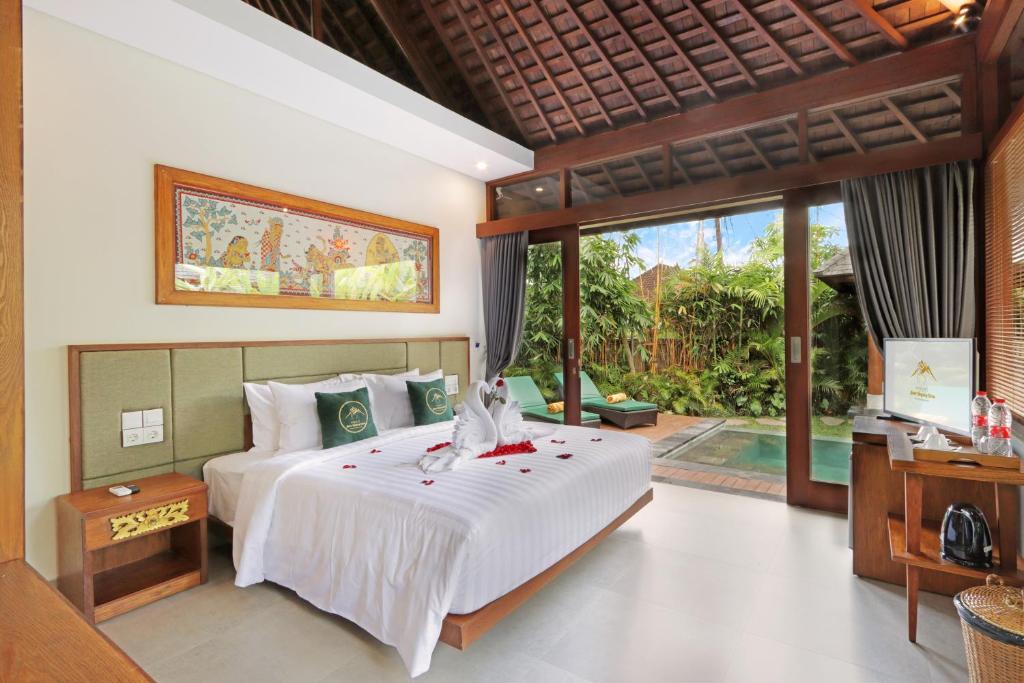 a bedroom with a large bed and a large window at Alam Wayang Ubud - CHSE Certified in Ubud
