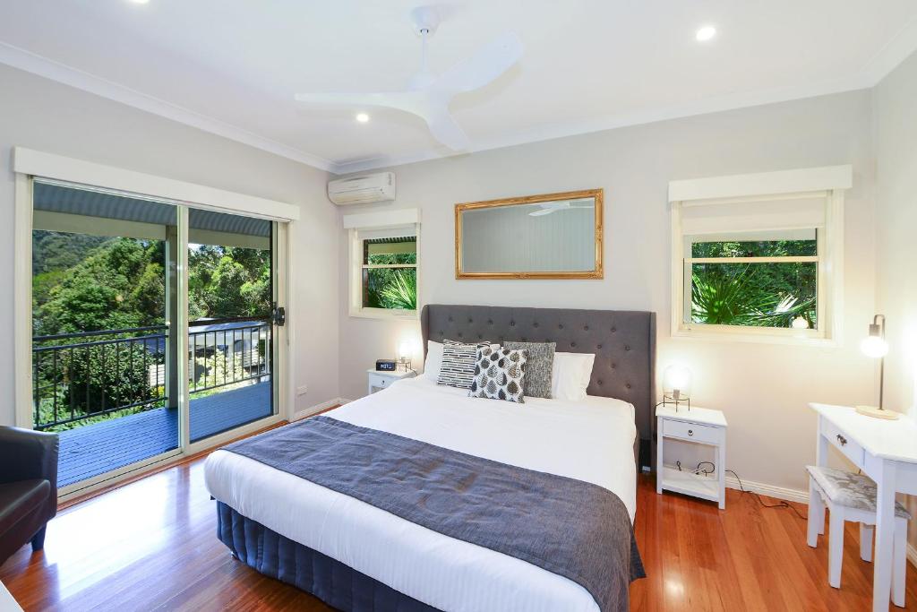 a bedroom with a bed and a large window at The Acreage Boutique Guesthouse in North Avoca