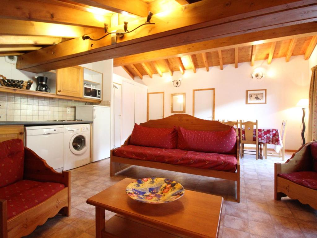 un salon avec un canapé rouge et une table dans l'établissement Appartement 7 pers. au centre de Val Cenis, proche pistes et commodités - FR-1-508-7, à Lanslevillard