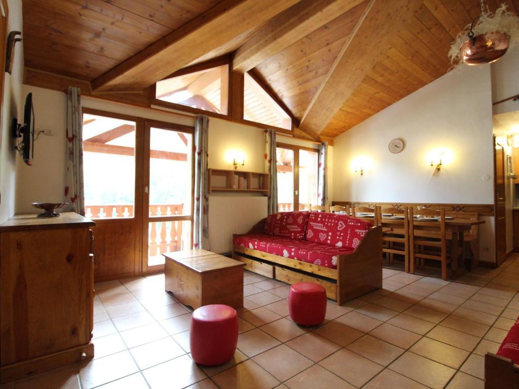 a living room with a red couch and a wooden ceiling at Appartement Lanslevillard, 5 pièces, 12 personnes - FR-1-508-69 in Lanslevillard