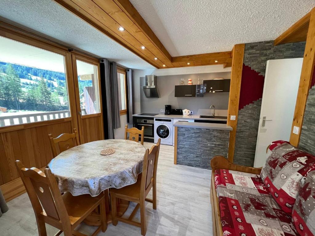 une cuisine et une salle à manger avec une table et des chaises dans l'établissement Appartement rénové 4 pers, terrasse, au pied des pistes à Val-Cenis - FR-1-508-178, à Lanslevillard
