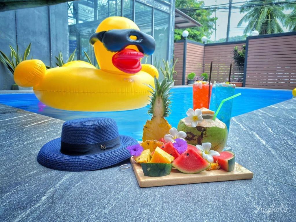 a plastic rubber duck with a hat and a tray of fruit at The Morning mini house aonang in Ao Nang Beach